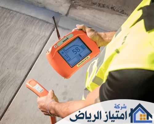 كشف تسربات المياه المنزلية في تبوك 0506986916 شركة امتياز الرياض فني يستخدم جهازاً إلكترونياً برتقالي اللون للكشف عن تسربات المياه أو الغاز تحت الأرض بدقة واحترافية.