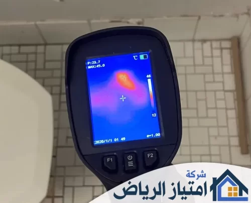 شركة فحص تسربات المياه بتبوك 0506986916 شركة امتياز الرياض كاميرا حرارية تكشف عن تسرب حراري خلف سيراميك الحمام، يظهر باللون الأحمر والبرتقالي وسط خلفية زرقاء باردة.