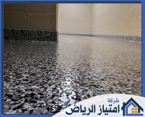 دهان ايبوكسي بالرياض 0506986916 شركة امتياز الرياض أرضية من رقائق الإيبوكسي عالية اللمعان في زاوية جراج نظيفة، تمزج بين النظافة والوظيفة.
