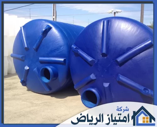 لحام خزان علوي بالرياض 0506986916 شركة امتياز الرياض مشهد خارجي يظهر خزاني بلاستيك زرقاوين دائريين ممددين على الأرض، مع فتحات دائرية كبيرة في المقدمة.